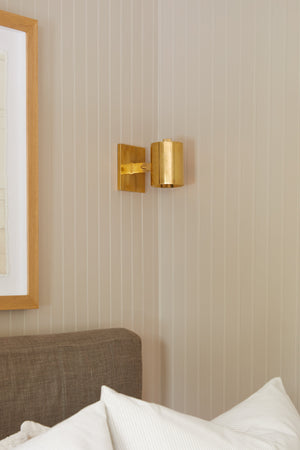 Highgrove Wall Sconce in aged brass styled in a modern bathroom for warm, layered light at Laurie Yapp Home.