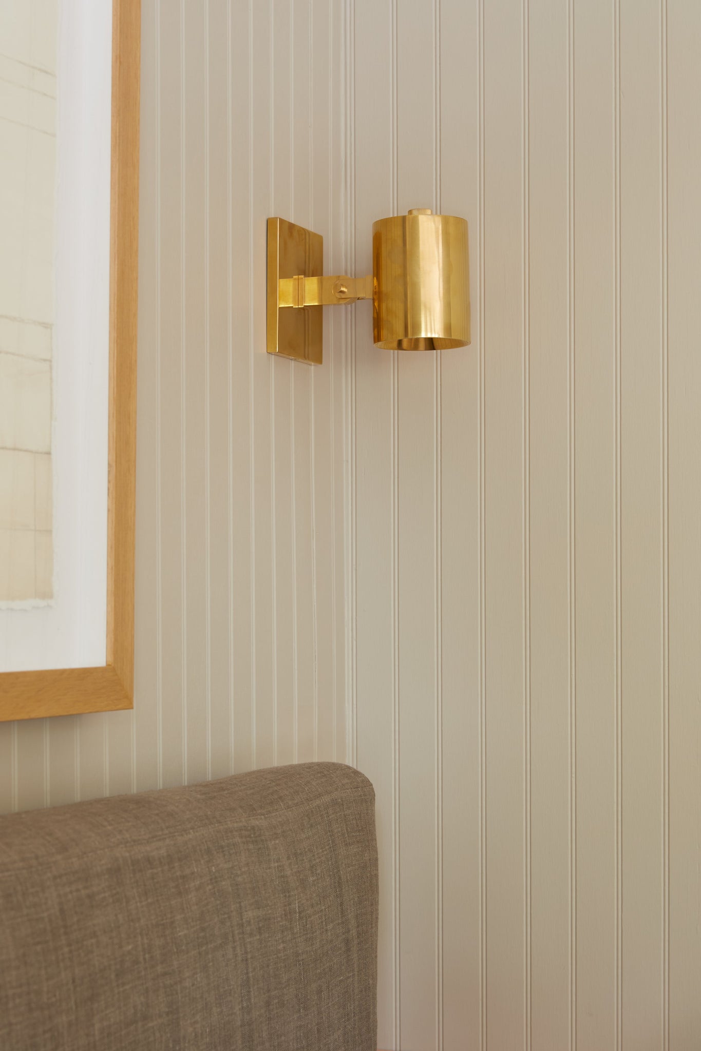 Highgrove Wall Sconce in aged brass styled in a warmly lit hallway for warm, layered light at Laurie Yapp Home.