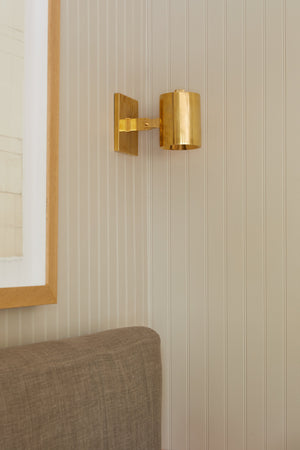 Highgrove Wall Sconce in aged brass styled in a warmly lit hallway for warm, layered light at Laurie Yapp Home.