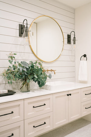 Ivy Wall Sconce in bronze styled in a modern bathroom for warm, layered light at Laurie Yapp Home.