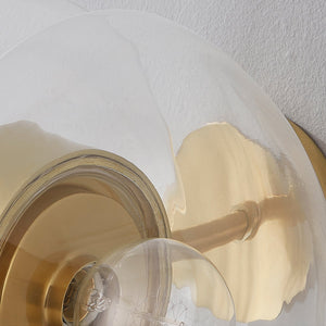 Kert Wall Sconce in aged brass shown from the front to reveal the arm curve and shade silhouette.