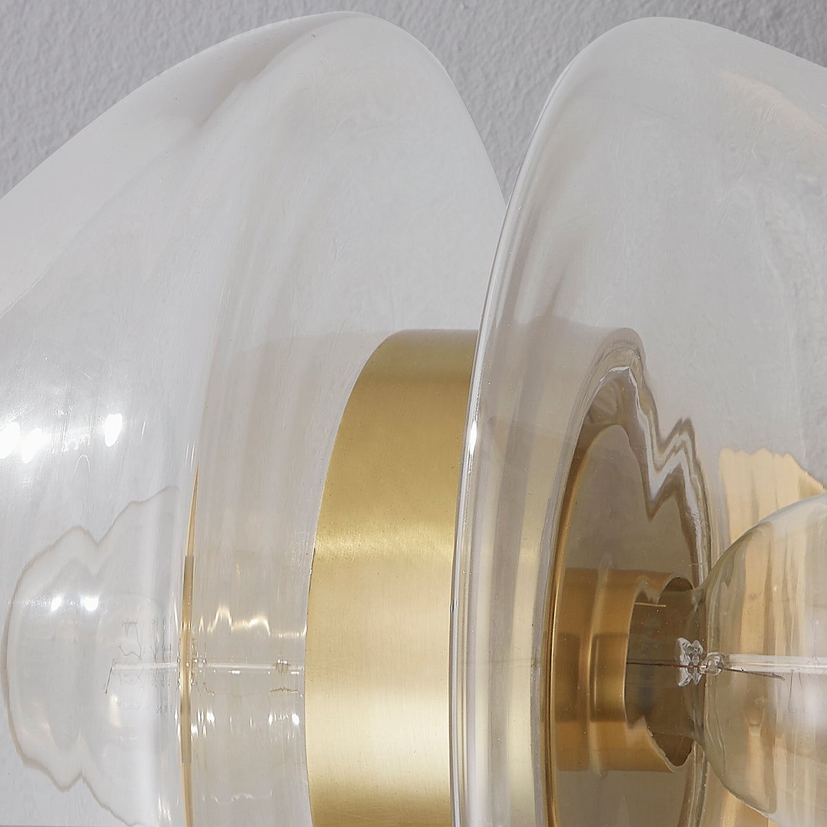 Close-up of the Kert Wall Sconce in aged brass showing the arm curve and shade silhouette.