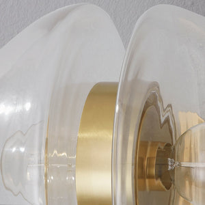 Close-up of the Kert Wall Sconce in aged brass showing the arm curve and shade silhouette.