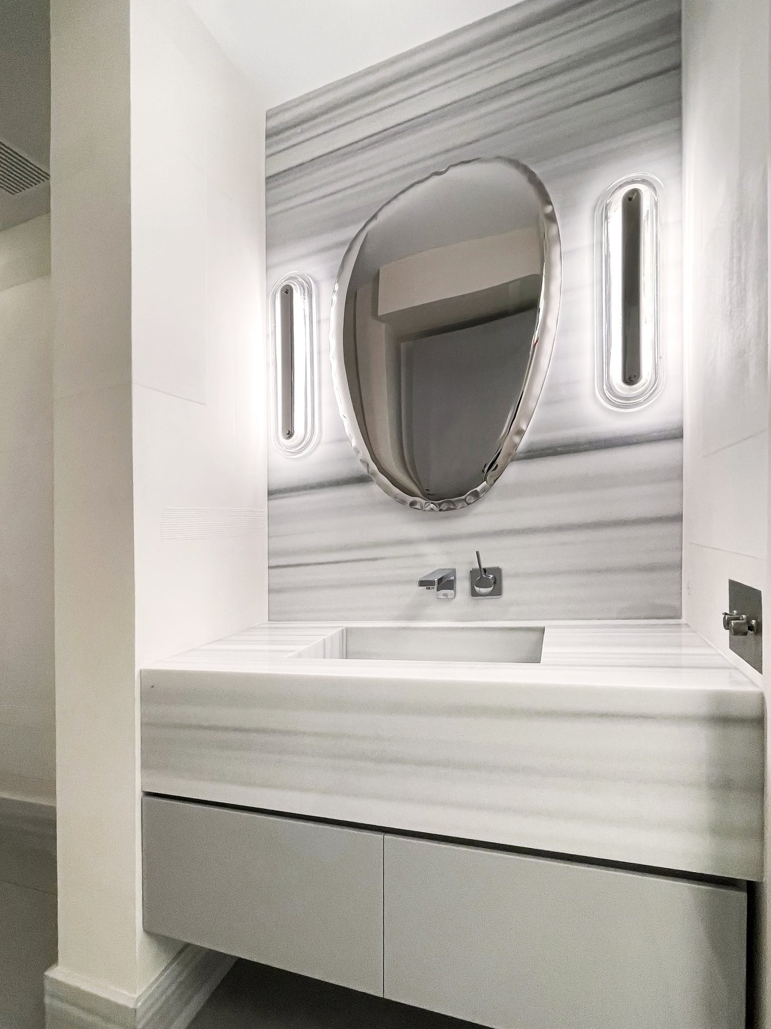 Litton Wall Sconce 5.75" x 21.25" in polished nickel styled in a modern bathroom for warm, layered light at Laurie Yapp Home.