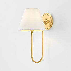 Close-up of the Hawthorne Wall Sconce in aged brass showing the arm curve and shade silhouette.