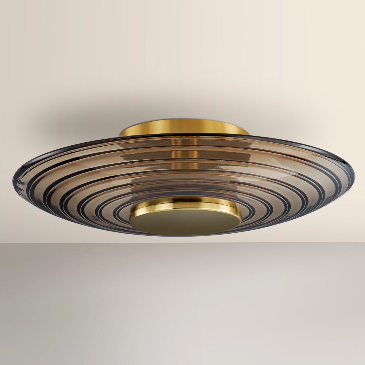 Griston Wall Sconce 12" x 12" in aged brass shown from the front to reveal the arm curve and shade silhouette.
