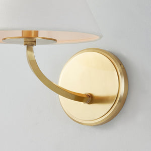 Close-up of the Stacey Wall Sconce in aged brass showing the arm curve and shade silhouette.