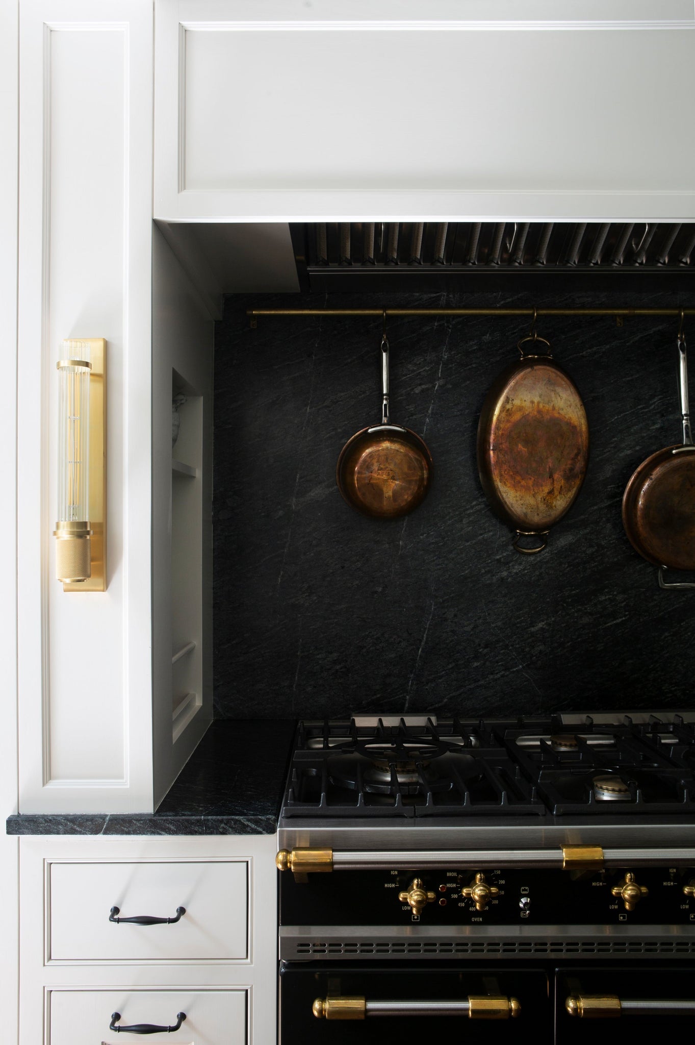 Shaw Wall Sconce in aged brass styled in a modern bathroom for warm, layered light at Laurie Yapp Home.