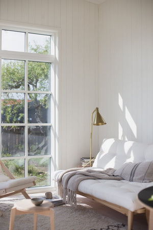 Stanton Floor Lamp in aged brass styled in a living room corner for warm, layered light at Laurie Yapp Home.
