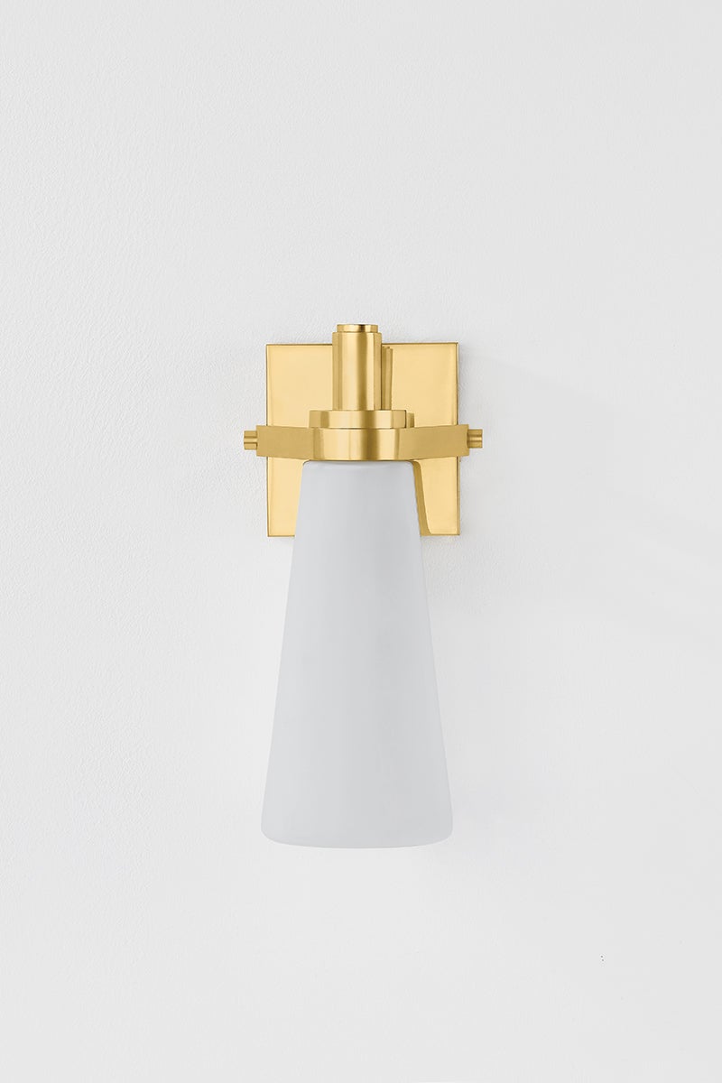 Trude Wall Sconce in aged brass shown from the front to reveal the arm curve and shade silhouette.