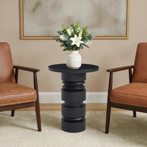 Talpa end table styled with a vase of flowers, placed between two brown chairs.