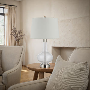 Lya Table Lamp in a living room setting on a wooden table, surrounded by cozy seating.