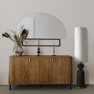 Pixel floor lamp beside a wooden sideboard with a mirror and decorative vase
