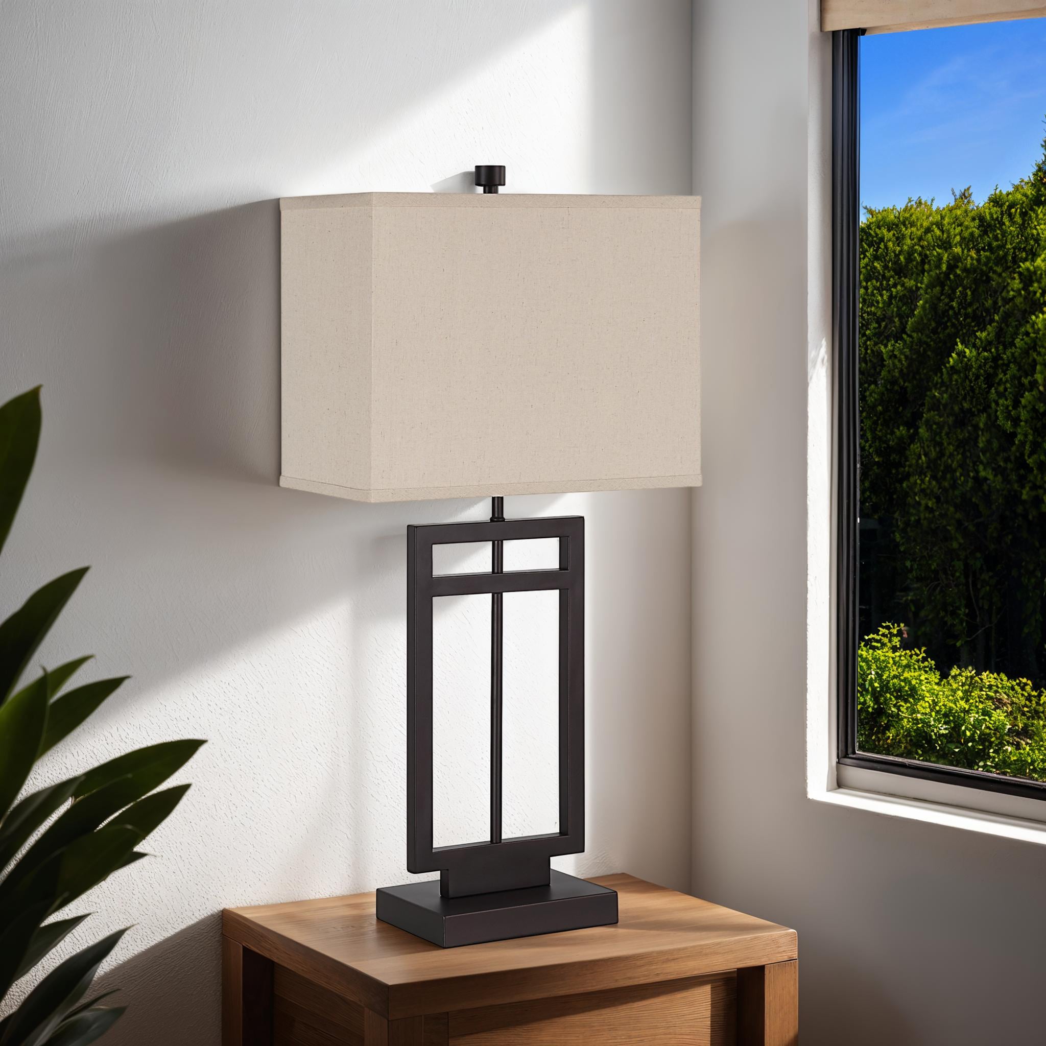 Sendai table lamp placed on a wooden table near a window, with a beige shade and dark base.