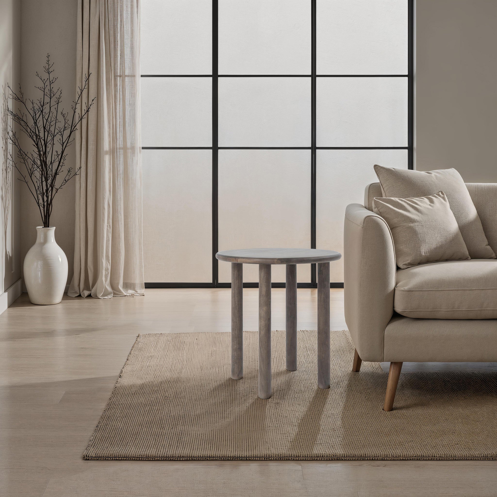 Cetus accent table in a modern living room with a light-colored sofa and large windows.