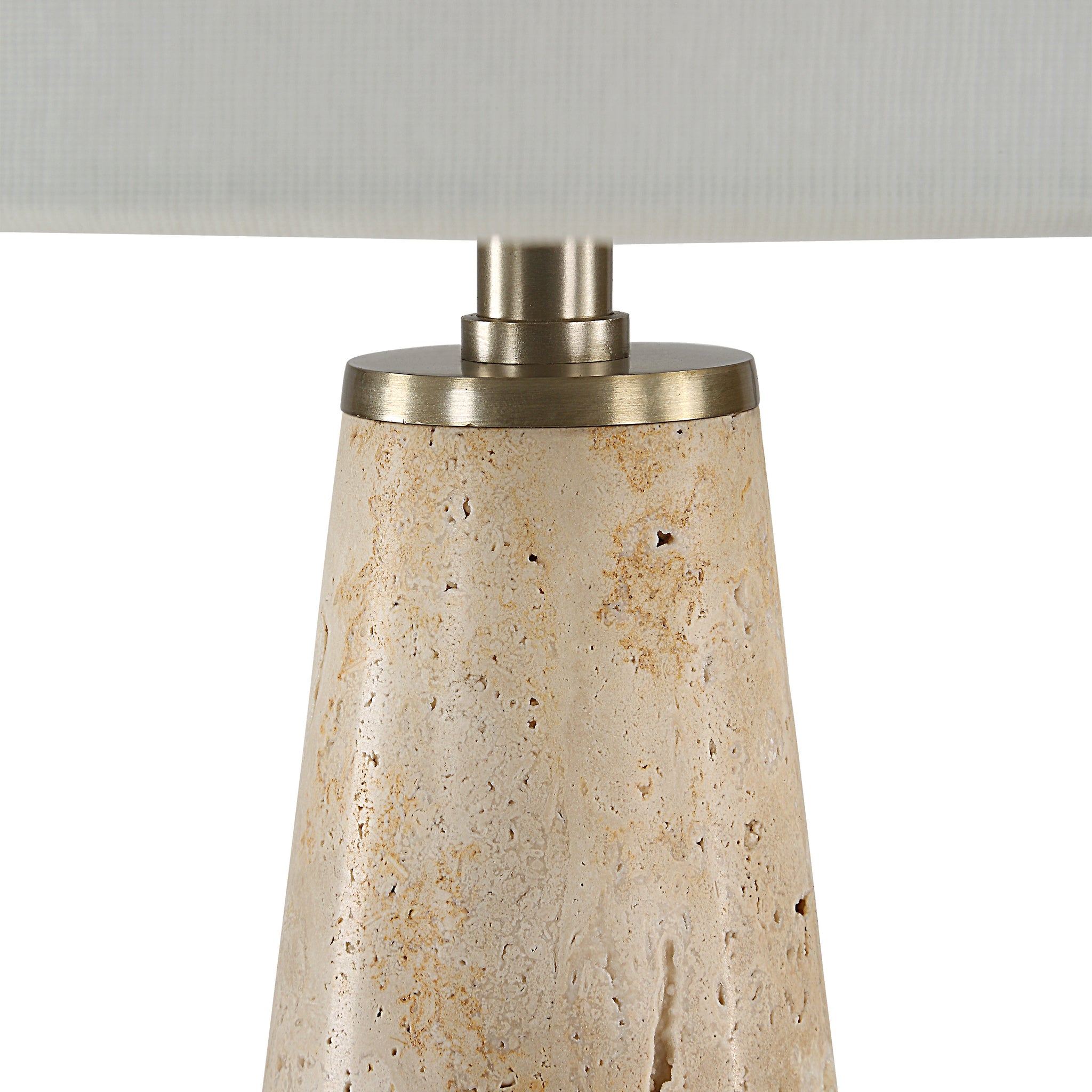 Close-up of Almeria table lamp base, featuring a textured beige stone and brushed metal accent.