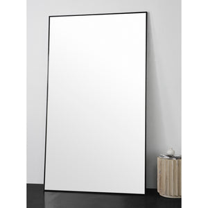 Keene Full Length Mirror positioned against a wall, showcasing its large reflective surface.