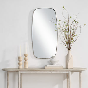 Jacossa mirror mounted on a wall above a wooden table with decorative items