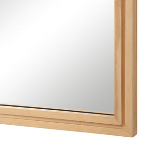 Close-up of Canas mirror's natural wood frame highlighting the smooth reflective surface.