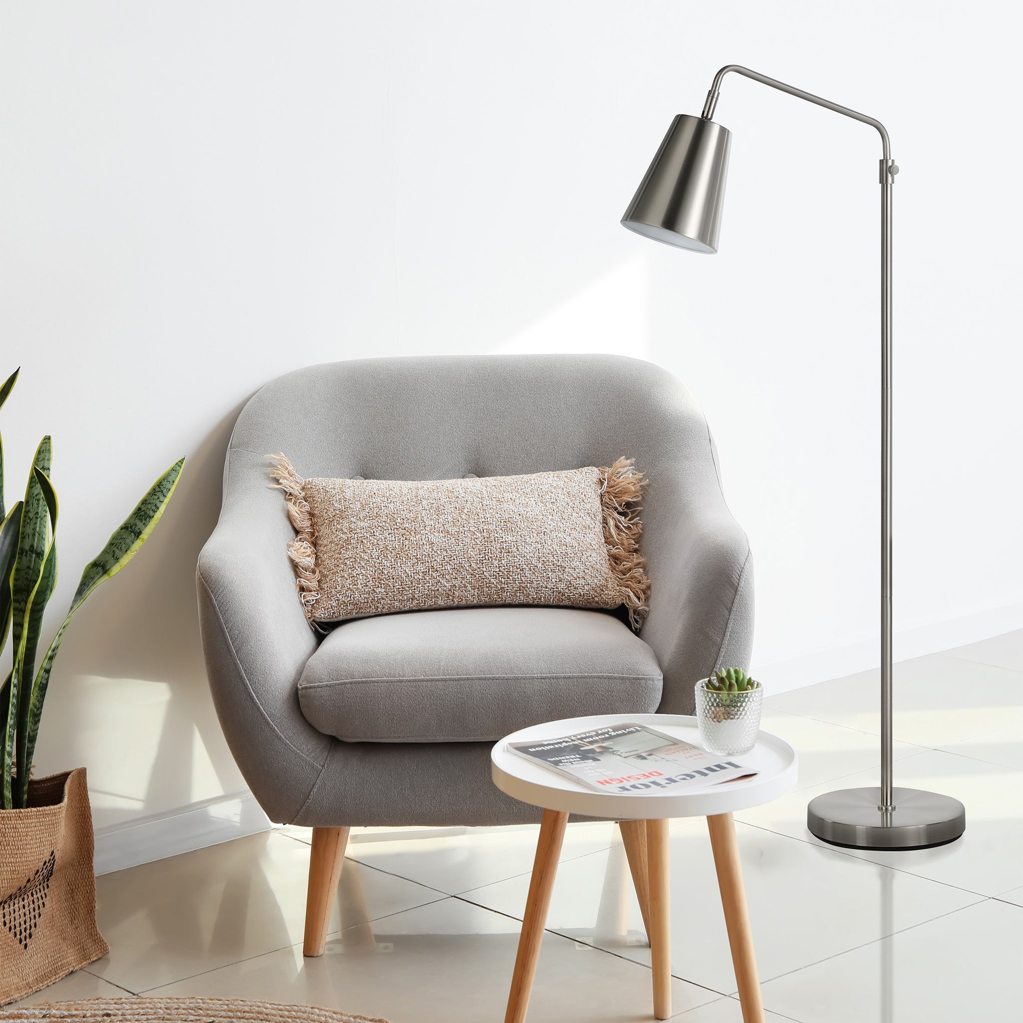 Norwich floor lamp beside a gray armchair with a decorative pillow and small table.