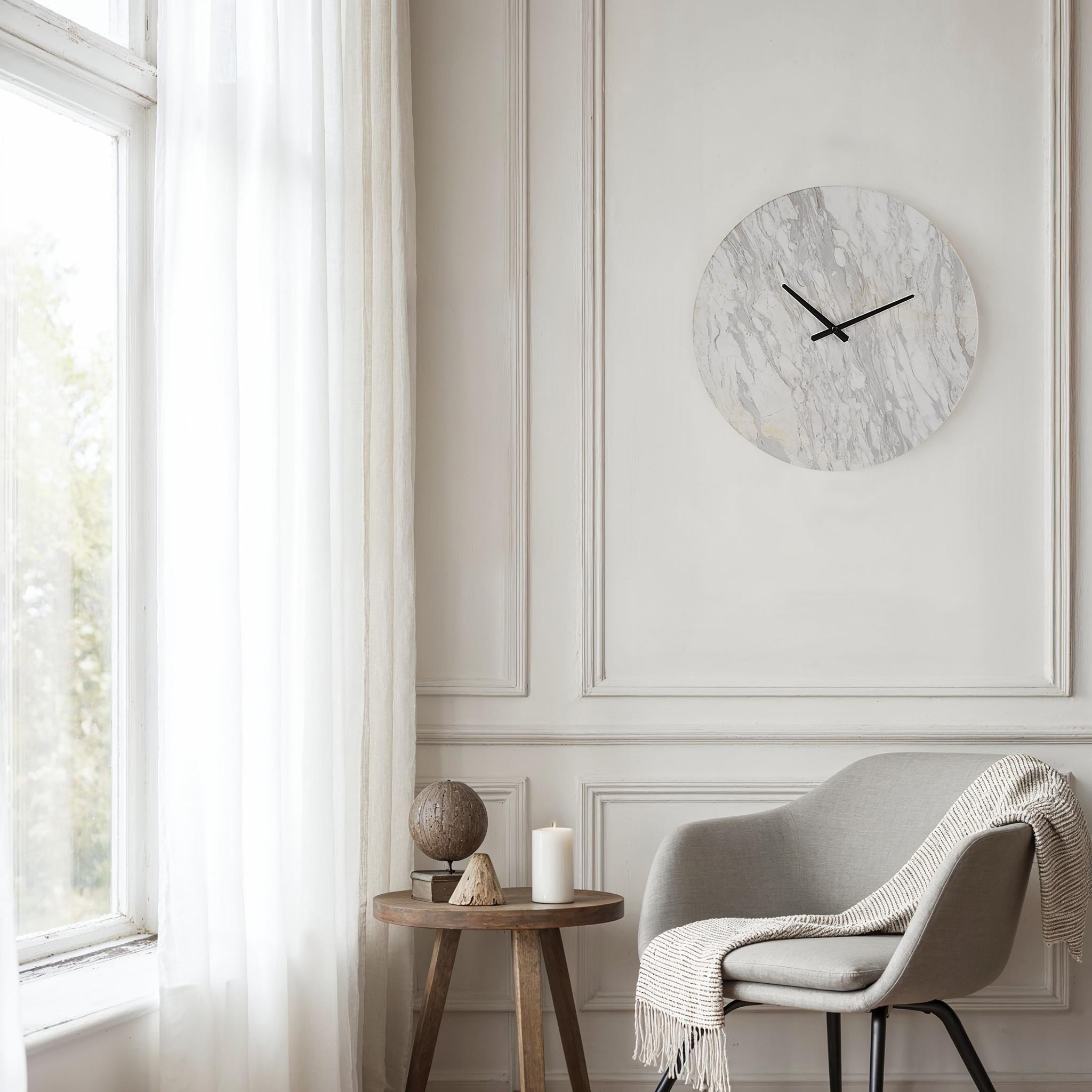 Dayton clock mounted on a wall in a bright room with a chair and decor