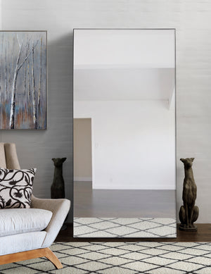 Trilo Full Length Mirror displayed in a modern living room with a cozy sofa and decorative art.