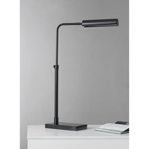 Fabolia Table Lamp in black, positioned on a desk with a book beside it.