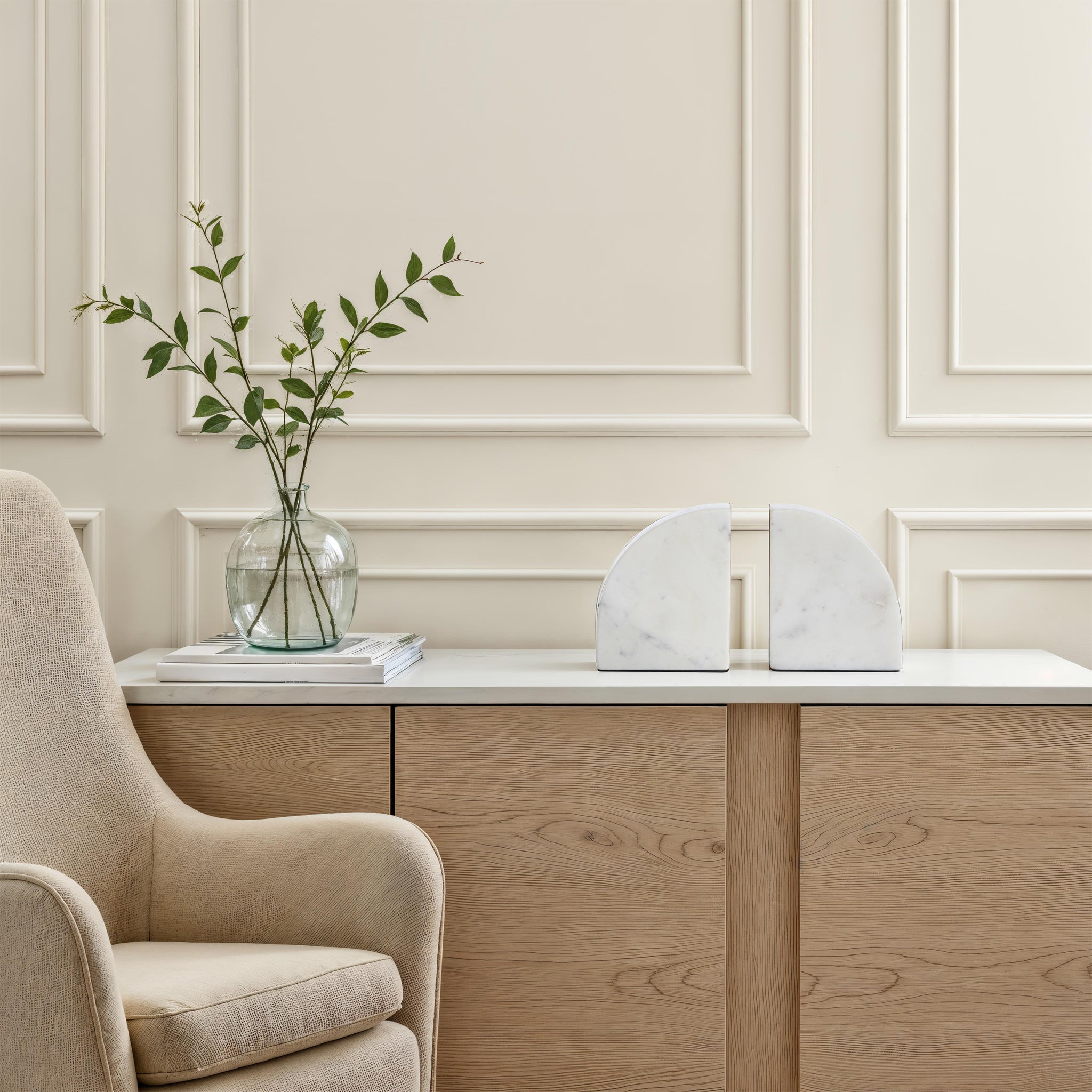 Carvella Bookends in Banswara Marble, placed on a modern table with a vase and chair in the background.
