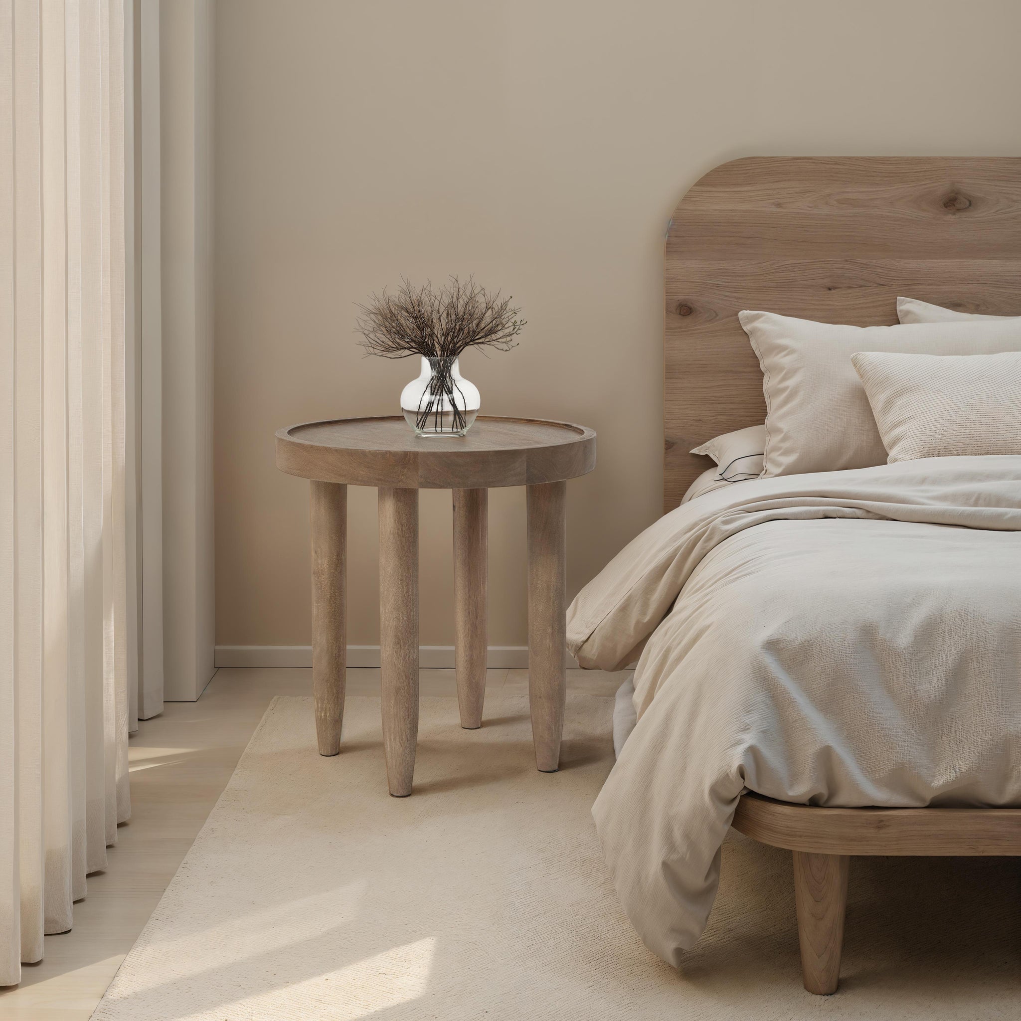 Cicoria side table styled in a bedroom with a vase and bedding in neutral tones