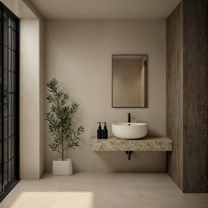 Agata mirror displayed in a modern bathroom setting above a stone sink.