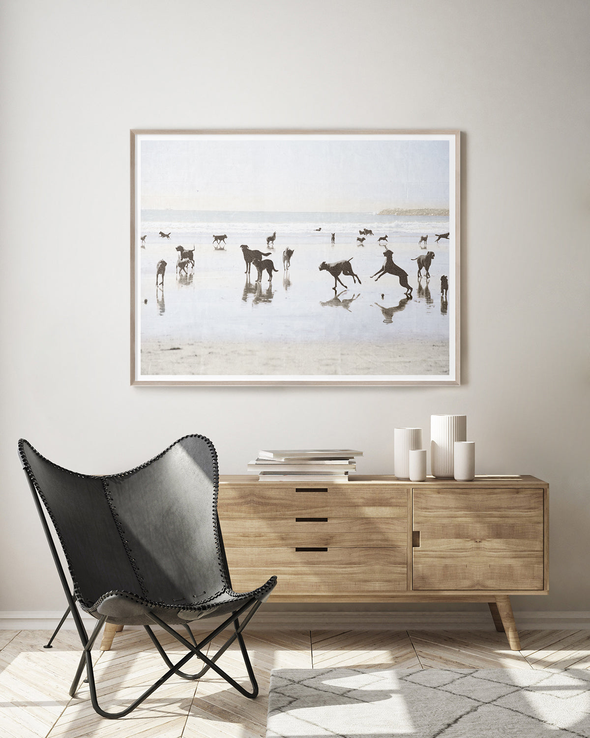 Silhouettes of dogs playing on a beach with a framed border.