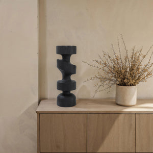 Beckton statue by Renwil on a wooden surface, paired with a vase and dried flowers.