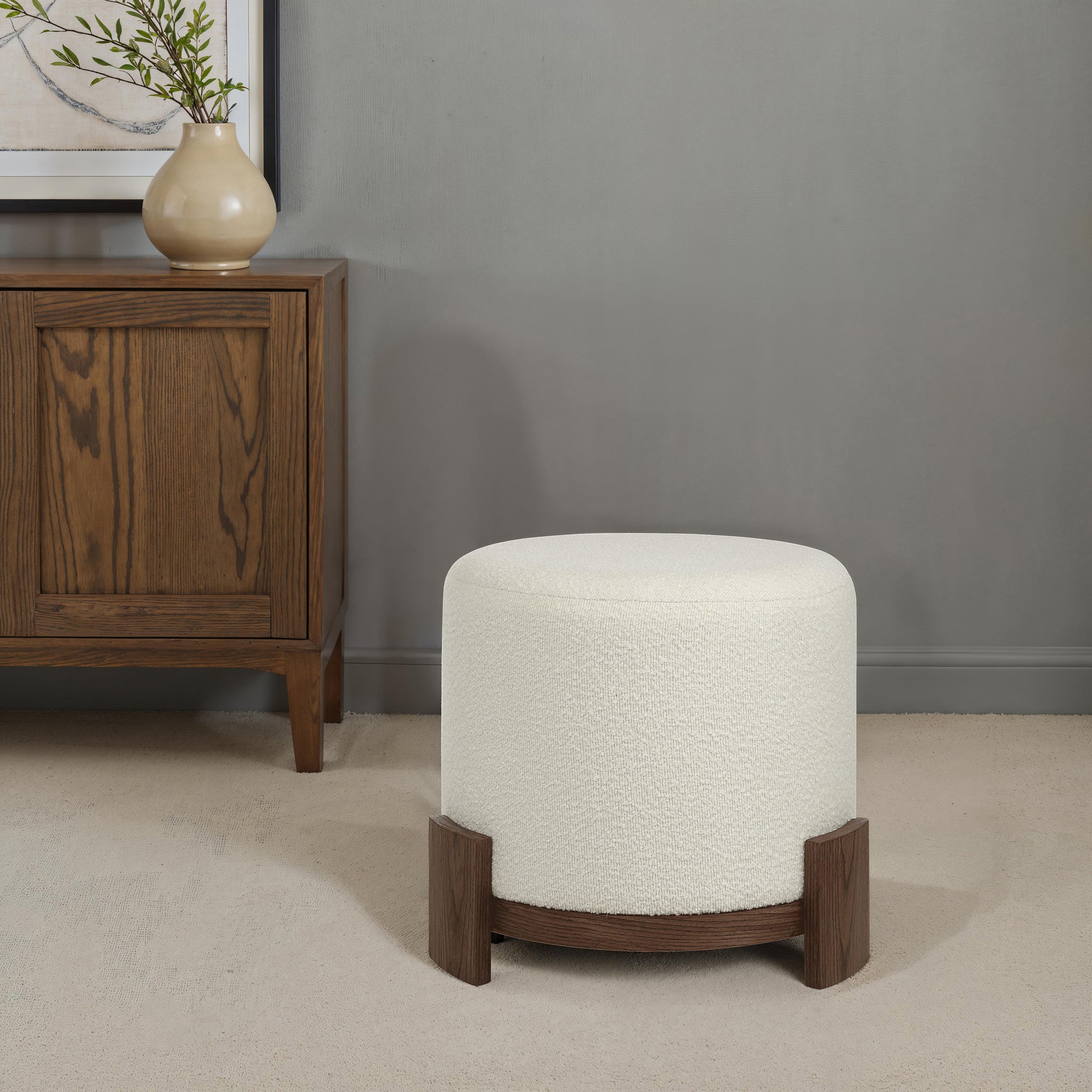 Chaves Ottoman by Renwil in a living room setting, cream fabric and dark wood base