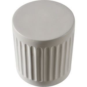 Lucian Table in light gray ceramic featuring a smooth top and ribbed sides, angled view.