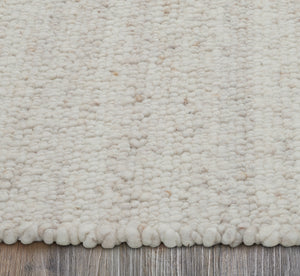 Edge view of Meghan rug highlighting its thick, soft pile in light beige tones.