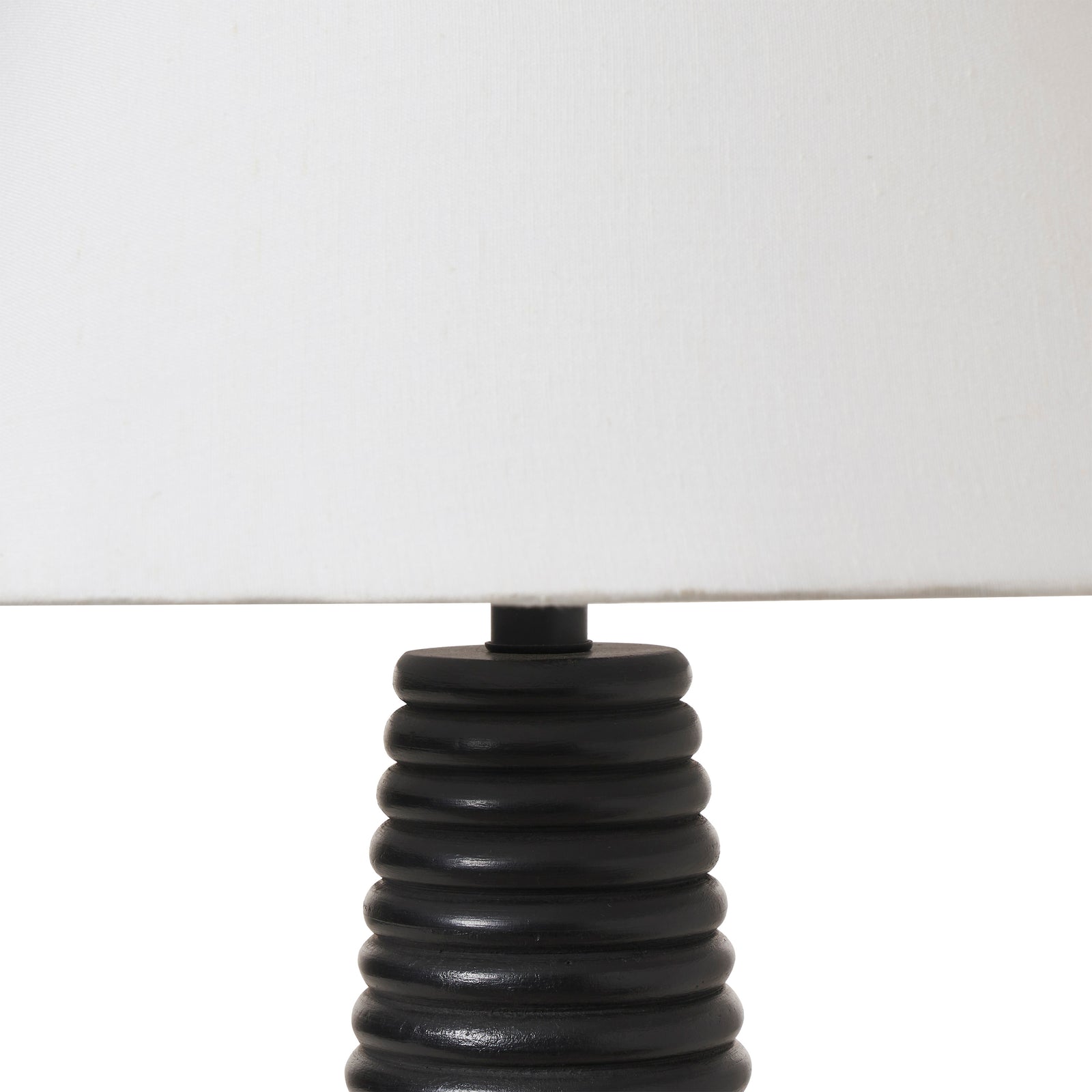 Kailua Table Lamp with a black ribbed base and white fabric shade, side view.