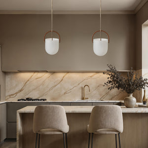 Brillio pendant lights above a modern kitchen island with beige tones and marble backsplash.
