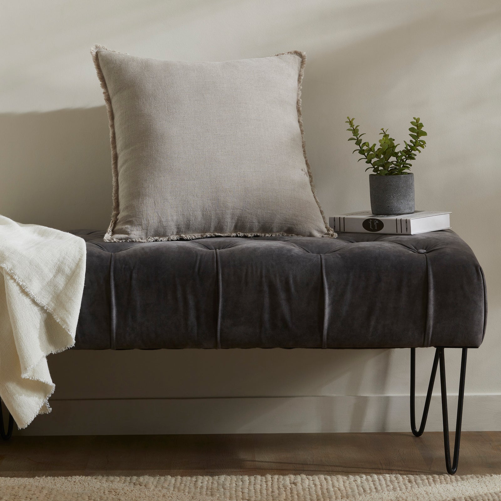 Ignatia Indoor Pillow in light beige with frayed edges, showcasing soft texture.