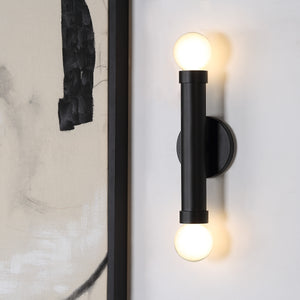 Alika Wall Sconce by Renwil, mounted on wall with illuminated round bulbs
