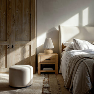 Noto Table Lamp beside a bed on a nightstand in a cozy bedroom setting.
