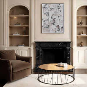 Yann canvas art featuring abstract shapes in neutral tones, framed in black, displayed above a fireplace.