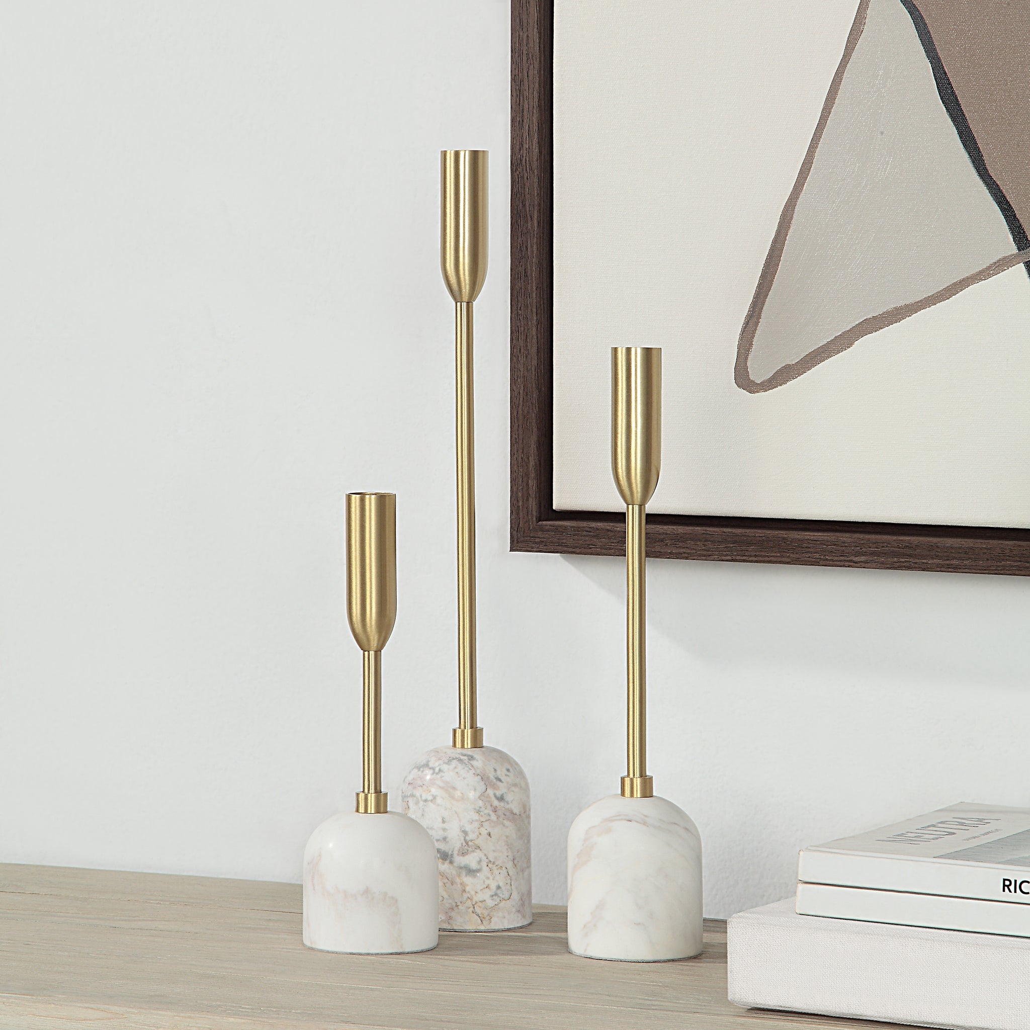 Marchesa Set of 3 Tapered Candle Holders displayed on a shelf with artwork in the background