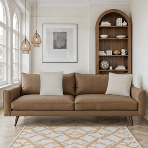 Pisces pillow on a brown sofa in a stylish living room setting.