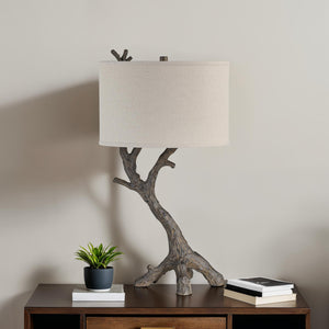 Loures table lamp on a wooden table with a small plant and books.