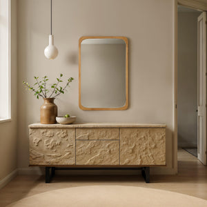 Scisto mirror displayed in a modern interior, above a textured sideboard with decor.
