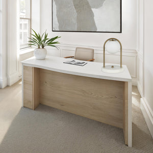 Barca table lamp on a modern desk with a plant and artwork in a bright office setting.