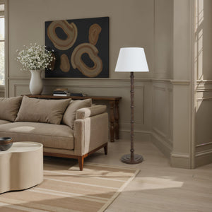 Odlam floor lamp in a cozy living room setting beside a beige sofa and artwork.