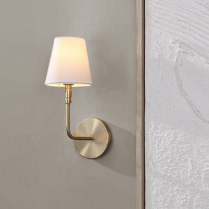 Milia Wall Sconce installed on a textured wall, illuminating with a warm glow.