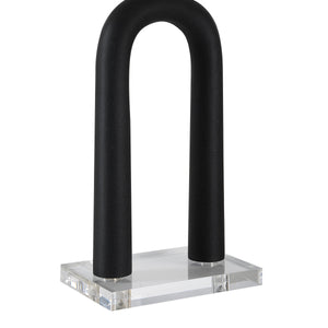 Close-up of Pisa Table Lamp showing black curved structure and clear acrylic base.