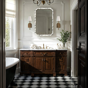Venus mirror with a marble frame above a wooden vanity in a stylish bathroom setting.